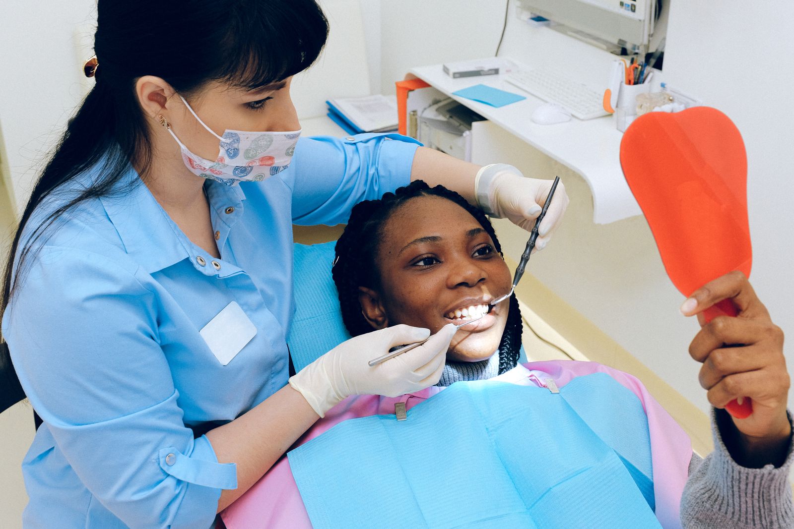Patient checking their smile in a hand mirror during a dental visit