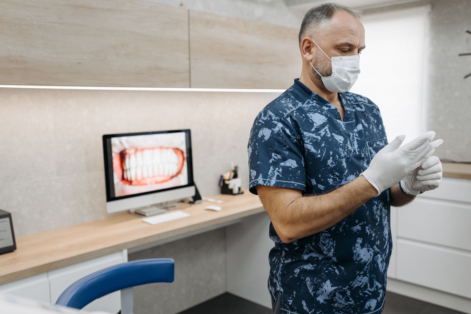 Dentist preparing for a private consultation with a dental scan on the desk computer